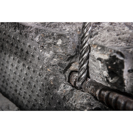 Borrat hål i betong med en spiralformad borrliknande metallstång införd.